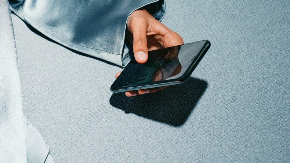 Person holding a smartphone, about to read or leave an online review for a restaurant or hotel